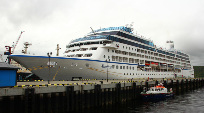 First cruise liner moors at distance line pier in the seaport of Murmansk